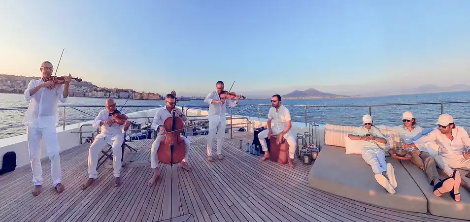 Ondanueve performing at sunset aboard a private yacht in the Bay of Naples